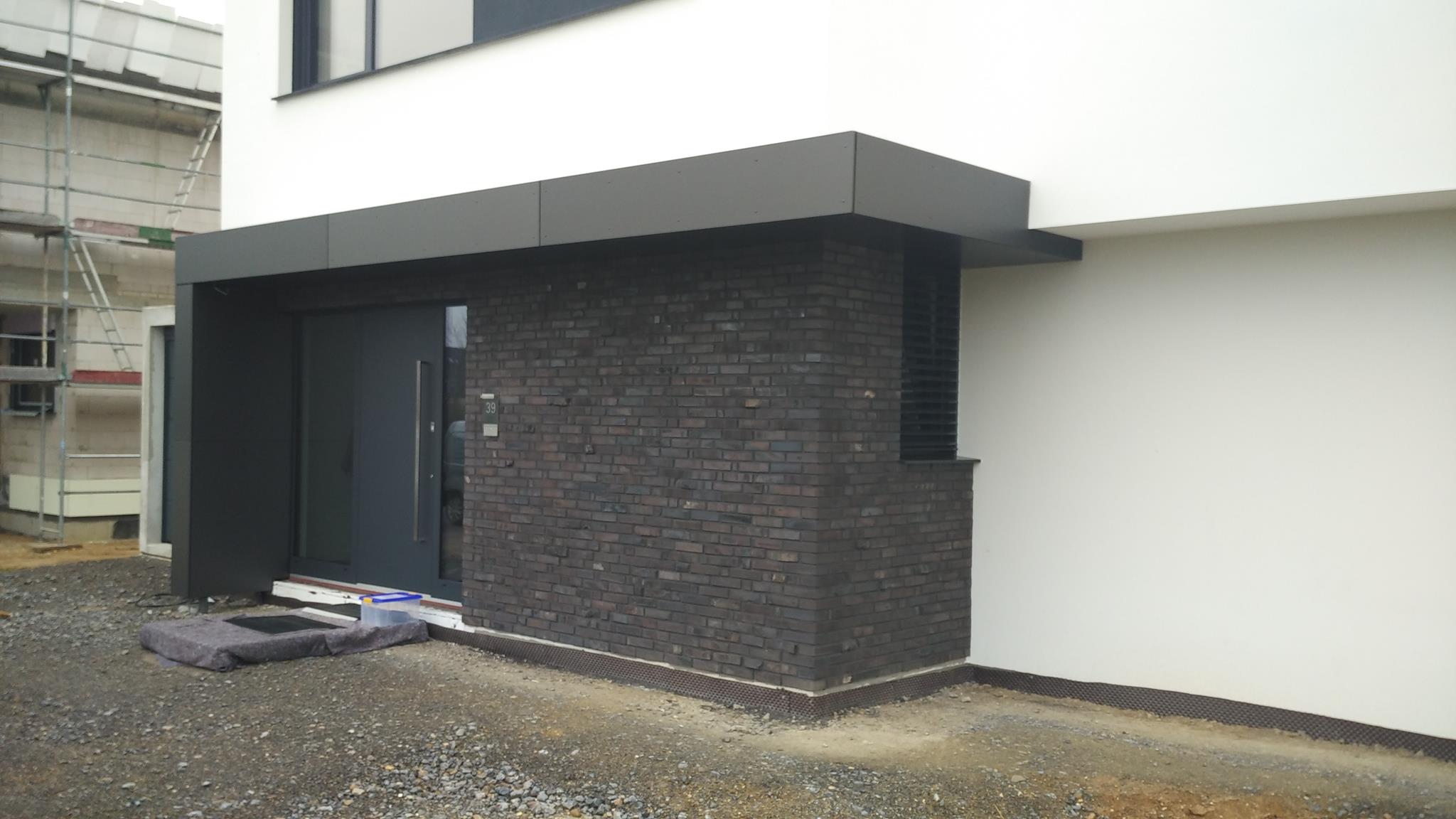 Dunkle Bauelemente an heller Fassade von Reimann-Bauelemente